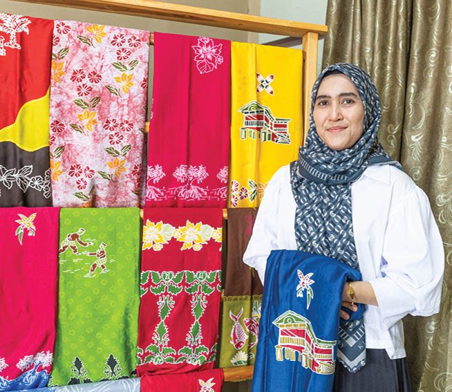 A woman wearing a headscarf stands in front of a display of colorful cloths. AI generated content