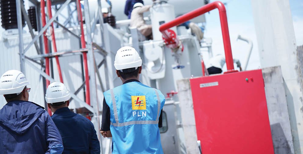 Three men wearing hard hats are standing in front of a power plant. AI generated content